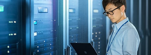 man in data center on laptop